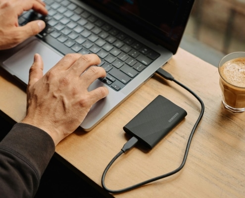 A man sitting at a table using a laptop computer